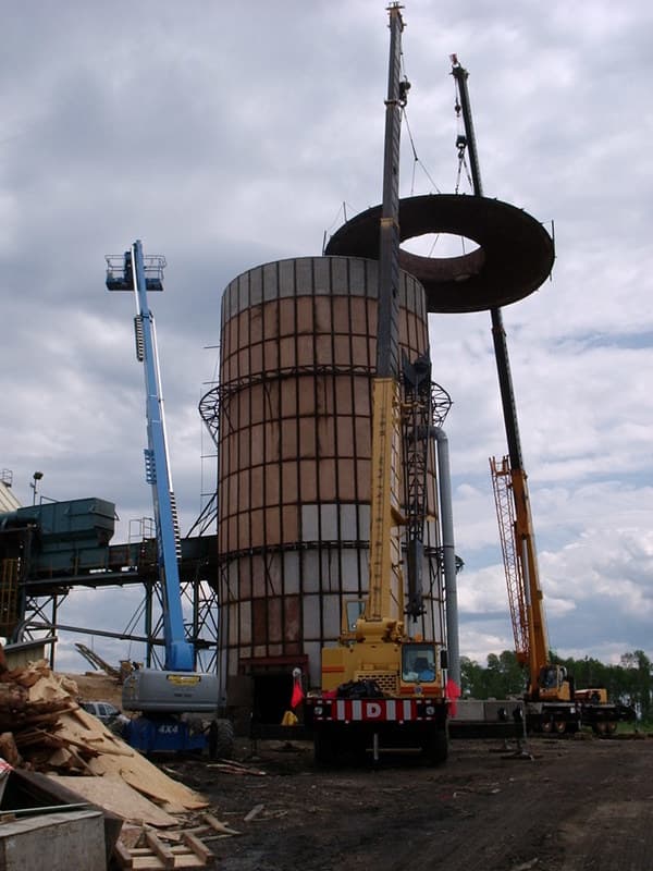 Cranes setting a steel ring section onto an industrial tank